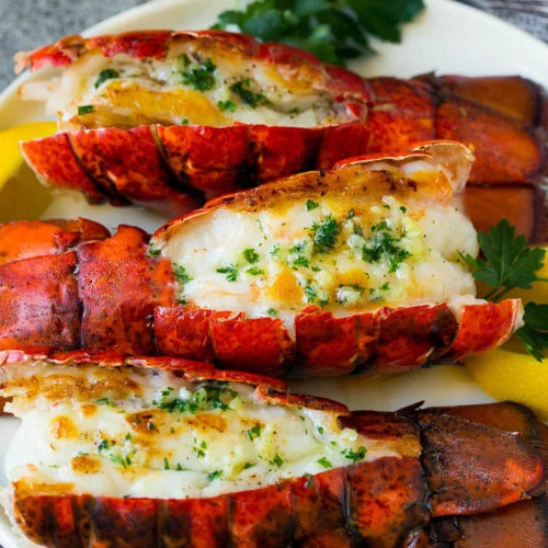 GRILLED LOBSTER (350g).  ( well seasoned lobster grilled with A touch of butter and olive oil Served with garlic sauce, sweet Corn,Pita bread and rosemary Potatoes